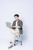 Jeune asiatique affaires homme séance sur chaise et en utilisant portable sur Contexte photo