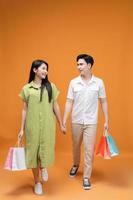 Jeune asiatique couple en portant achats sac sur Contexte photo