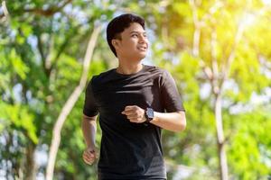 Jeune asiatique homme profiter en plein air faire des exercices dans le Matin. concept de personnes, sport et force. photo