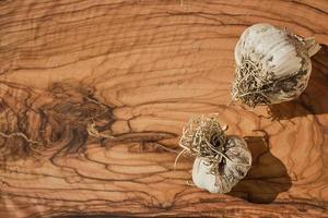 tête de Frais Ail sur une en bois Coupe planche. Ail est un de le plus populaire épices dans le monde. Les agriculteurs Ail est choisi pièces de une vivace plante de le oignon famille. photo