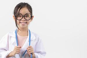 Asie peu fille en jouant médecin isolé sur blanc photo