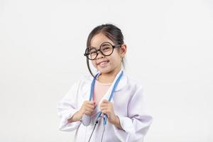 Asie peu fille en jouant médecin isolé sur blanc photo