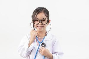 Asie peu fille en jouant médecin isolé sur blanc photo