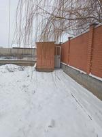 Cour briques village toilette avec mur dans neigeux temps. hiver paysage cour. photo