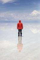 Jeune homme en veste à capuche d'hiver au salar de uyuni salt flat en bolivie photo