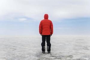 Jeune homme en veste à capuche d'hiver au salar de uyuni salt flat en bolivie photo