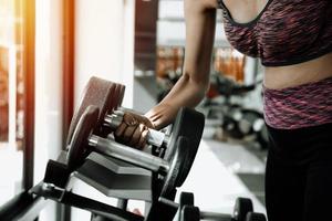 Femme de remise en forme en formation avec des abdos forts montrant à la salle de sport photo