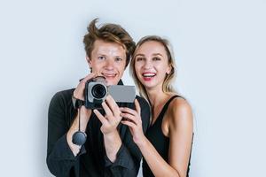Heureux portrait de couple tenant une caméra vidéo et l'enregistrement d'une vidéo