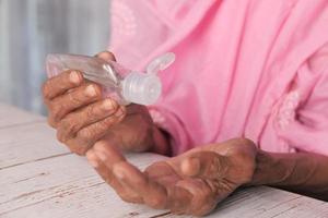 personne âgée utilisant un désinfectant pour les mains
