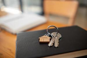 maison clés sont mis dans réel biens Bureau prêt à être remis plus de à client qui signé réel biens Contrat dans le bureau. concept de Accueil livraison à les clients après contracter. photo