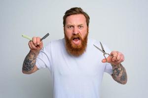 agressif homme avec les ciseaux et lame est prêt à Couper le barbe photo