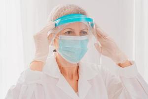 médecin régler le visage protecteur écran contre covid-19 virus photo