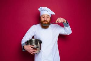 content chef avec barbe et rouge tablier est prêt à cuisinier photo