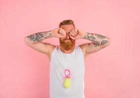 cri homme avec barbe et tatouages actes comme une petit nouveau née photo