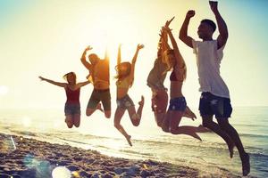 content souriant copains sauter à le plage photo