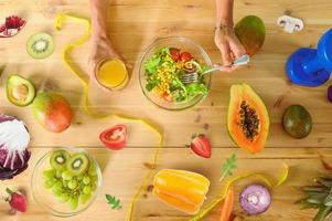 femme prépare une en bonne santé repas avec salade et Orange jus photo