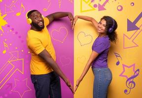 couple avec casque Ecoutez à la musique et faire le forme de cœur avec bras. violet et Jaune Contexte photo