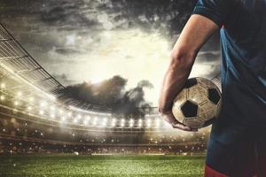 football joueur prêt à jouer ou donner un coup le Balle dans le sien mains à le stade photo