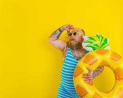 graisse étonné homme avec perruque dans tête est prêt à nager avec une Donut bouée de sauvetage photo