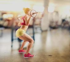 athlétique fille travaux en dehors à le Gym avec une haltère photo