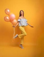 fille prêt pour une fête avec ballon. joyeux un bonheur expression. Jaune Contexte photo