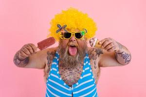 graisse homme avec barbe et perruque mange une popsicle et un crème glacée photo