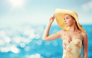 fille avec chapeau à le plage avec une brillant mer photo