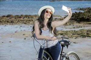 Jeune femme avec bicyclette selfie photo