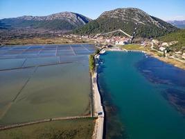 vue aérienne par drone de la saline dans la ville de ston en croatie. murs fortifiés dans les collines en arrière-plan. champs de sel. salines de ston. tourisme près de la mer adriatique. visites historiques. photo