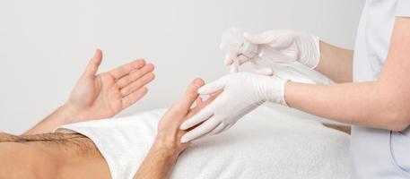 infirmière désinfectant les mains des mains d'un patient masculin photo