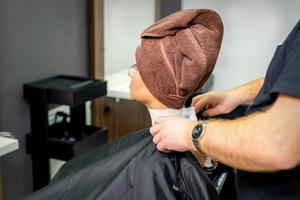 coiffeur met sur noir cap à femelle client photo