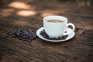 tasse à café et grains de café sur table en bois photo