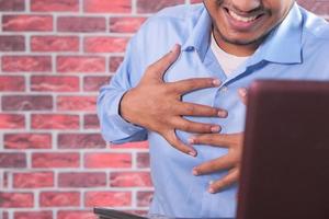 homme serrant la poitrine de douleur photo