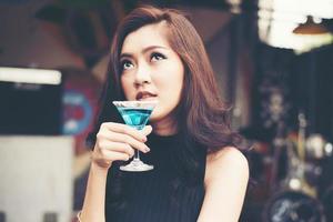 Portrait d'une jeune femme heureuse s'amuser et boire un cocktail photo