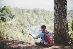 Randonneur jeune femme lisant une carte lors d'une randonnée photo
