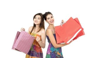 Deux jeunes femmes portant des sacs à provisions isolés sur fond blanc photo