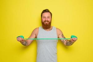 homme avec barbe et tatouages les trains avec une caoutchouc bande photo