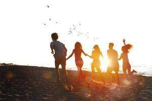 groupe de copains courir dans le mer. concept de heure d'été photo