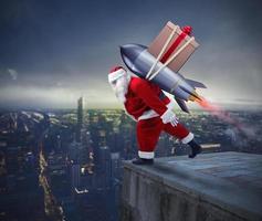 vite livraison de Noël cadeaux. Père Noël claus prêt à mouche avec une fusée photo