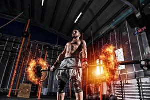 athlétique homme travaux en dehors à le Gym avec une ardent haltère photo