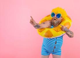 graisse étonné homme avec perruque dans tête est prêt à nager avec une Donut bouée de sauvetage photo