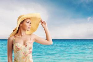 fille avec chapeau à le plage avec une brillant mer photo