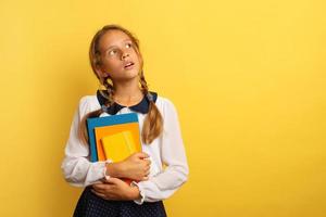 Jeune étudiant regarder quelque chose avec demandé expression. Jaune Contexte photo