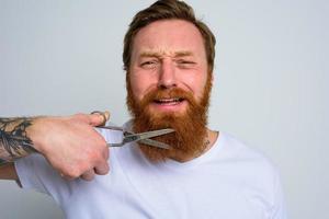 malheureux homme avec les ciseaux biches ne pas vouloir à Couper le barbe photo