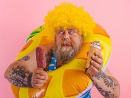 graisse homme avec barbe et perruque mange une popsicle et un crème glacée photo