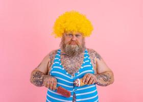 graisse homme avec barbe et perruque mange une popsicle et un crème glacée photo