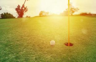 le golf Balle près le trou dans une herbe champ photo