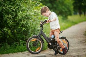 le garçon est équitation une bicyclette sur le rue photo