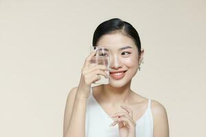 asiatique femme en buvant l'eau sur beige Contexte