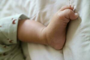 mignonne pieds de une nouveau née bébé sur une blanc matelas photo